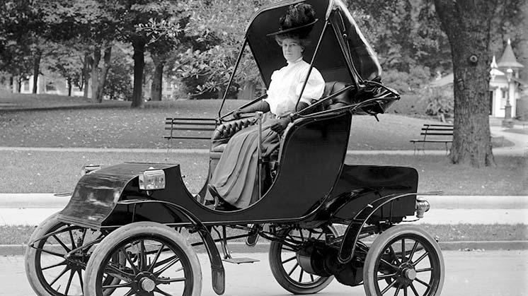 Mujer conduciendo un auto eléctrico en los años 1910.