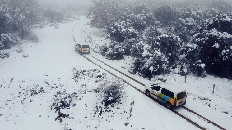 Furgonetas de Iberdrola circulando entre nieve en el parque eólico Sierra de Dueña en Las Veguillas