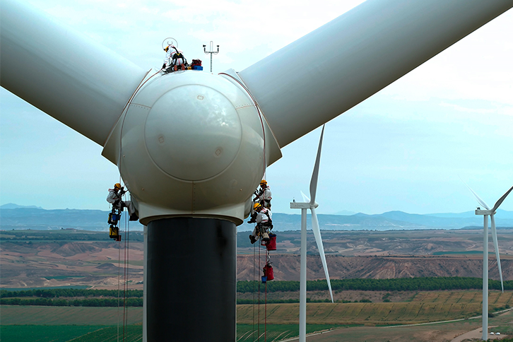Operadores trabalhando em uma turbina eólica.
