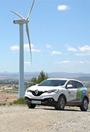 Imagem mostrando um carro chegando a um parque eólico.