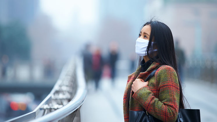 A woman is protected from air pollution by a mask.