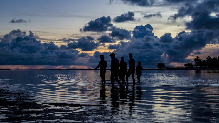 Un grupo de personas cruza la laguna en Tarawa, Kiribati.