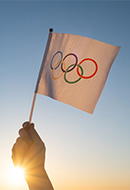 Mano con bandera con logo de los Juegos Olímpicos